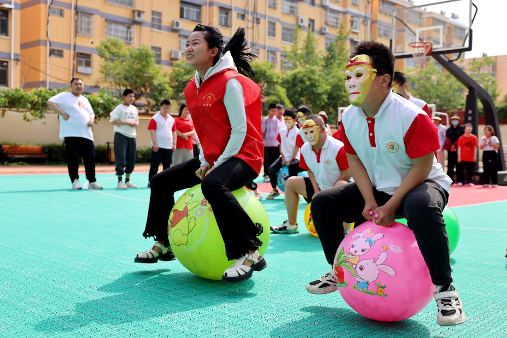 2024年5月17日，在山東省棗莊市市中區特殊教育中心，青年志愿者與智力障礙學生一起做游戲。新華社發（孫中喆攝）